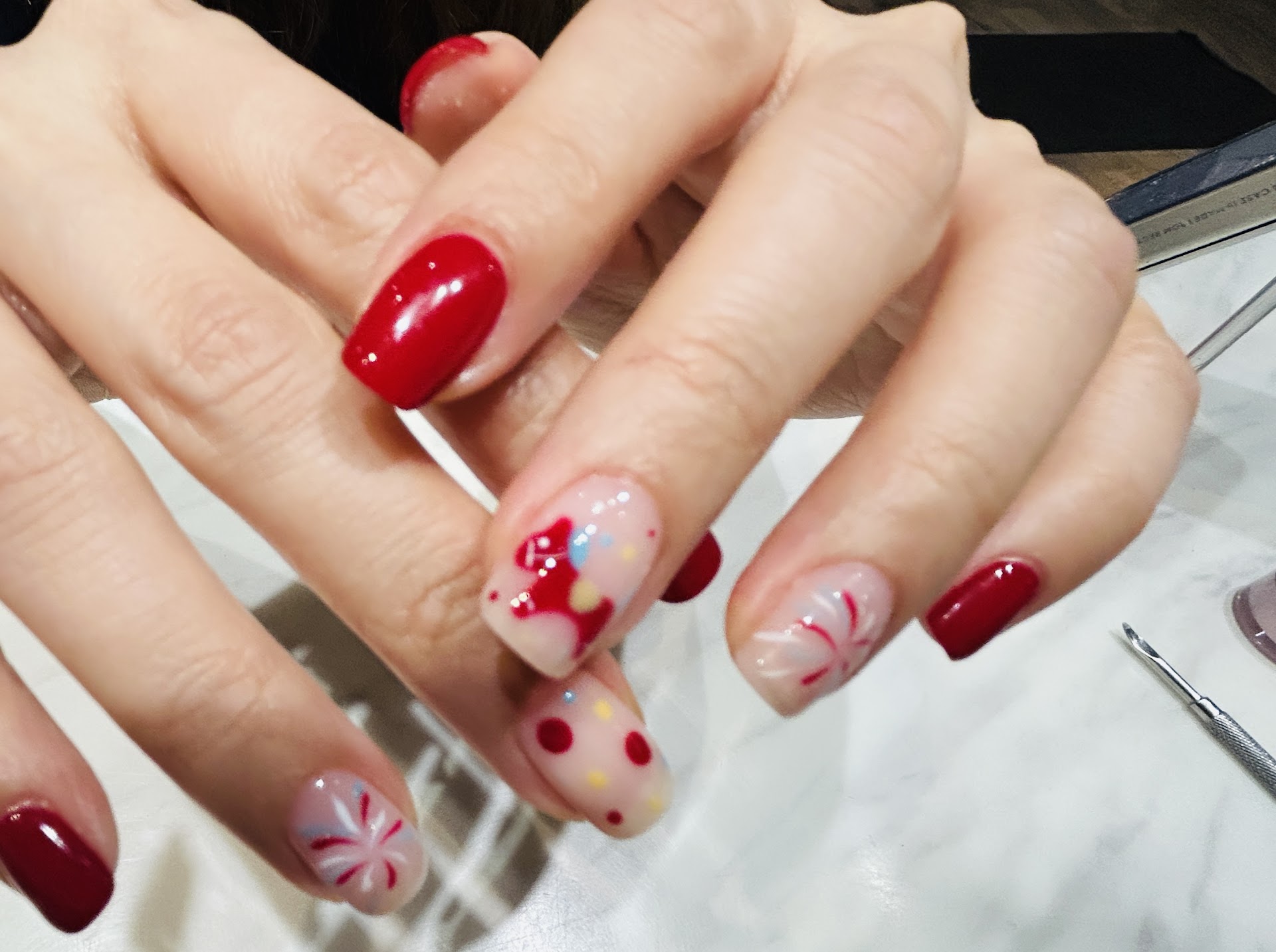 Glossy red nails with playful accent art